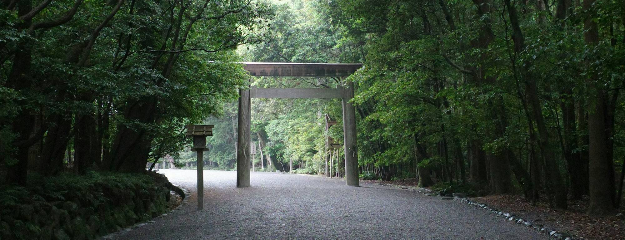 木々に囲まれた砂利の参道と鳥居