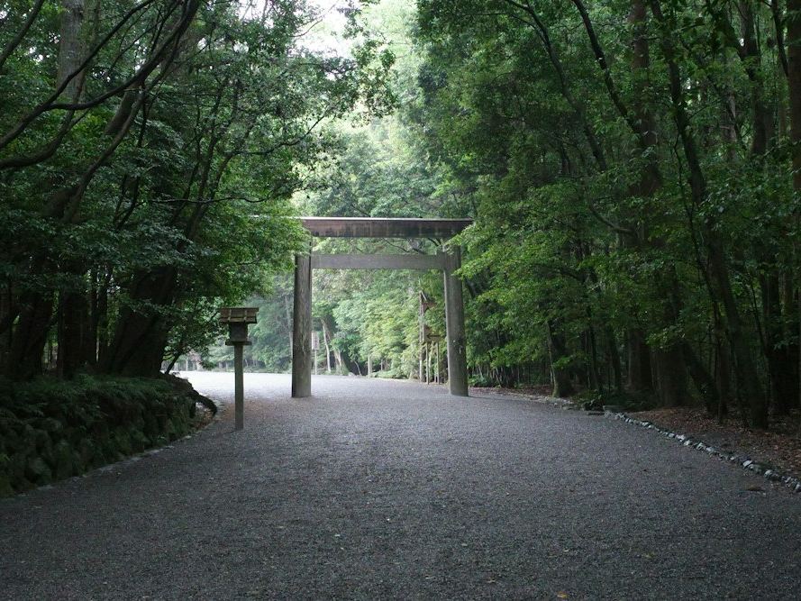 木々に囲まれた砂利の参道と鳥居